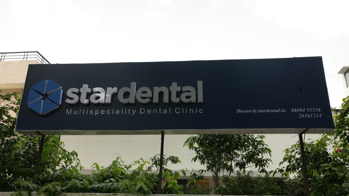 The interior of a dental clinic in New Delhi showing a treatment chair and equipment under overhead lighting.