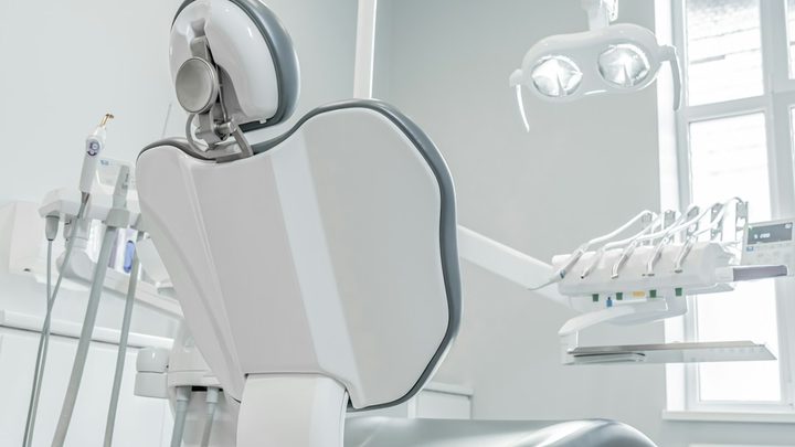 An empty dental operatory with the chair and equipment ready for the next patient